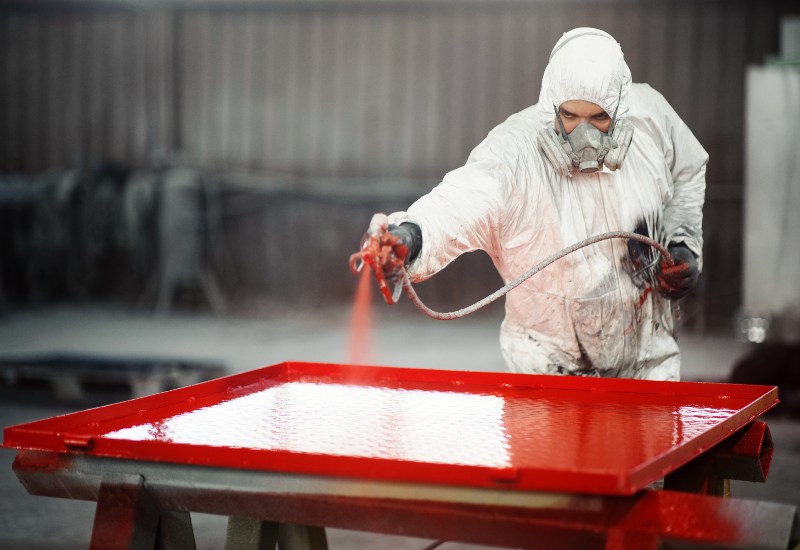 A team member from Eco-Clean Inc. is applying thermoplastic powder to a metal in Atlanta, GA