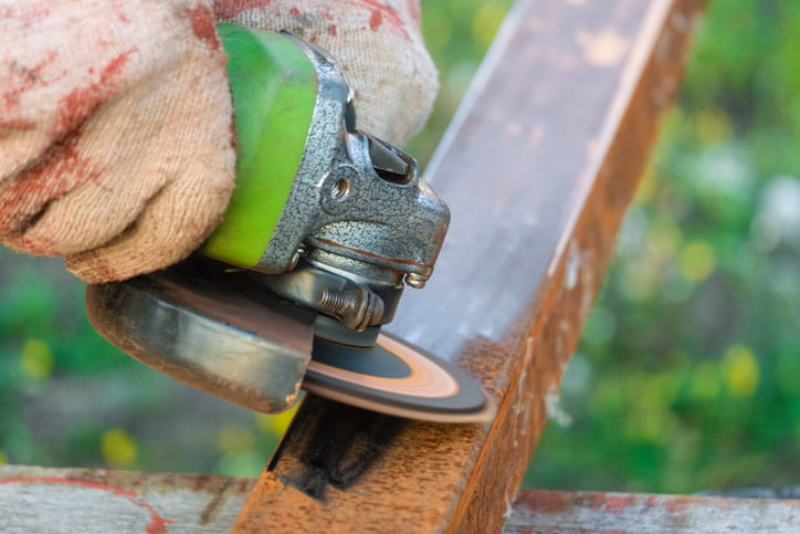 Angle grinder removing rust from the metal beam surface in Atlanta, GA