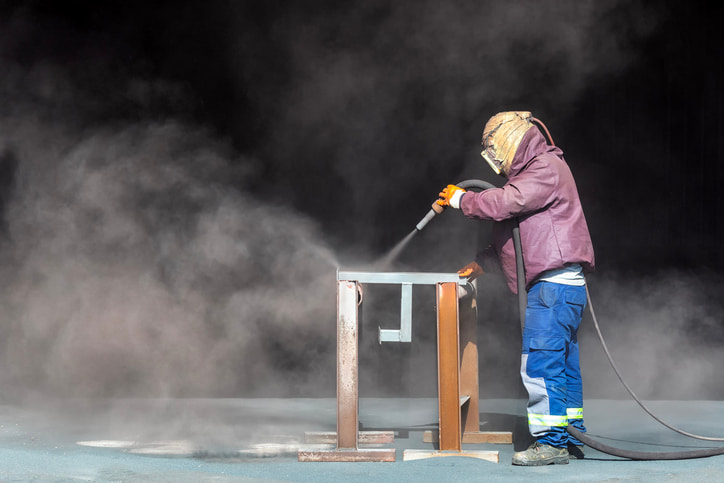 A professional removing metal coatings from the steel surface in Atlanta, GA